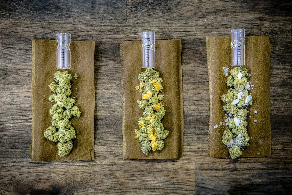 Three opened hemp wraps filled with flower
